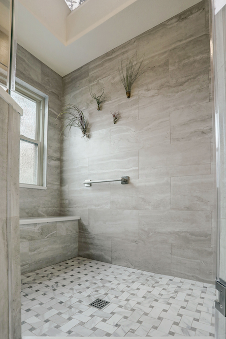 Brannon Cove shower with gray wall tile, a tiled bench and a geometric mosaic floor