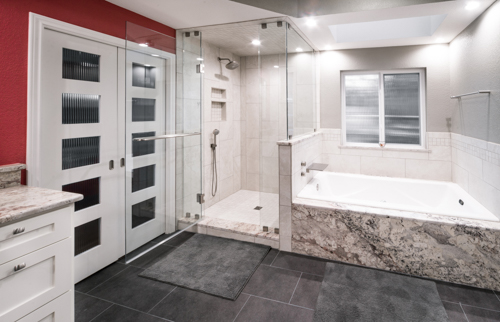 Bathroom with tiled shower walls, a tub surround and dark rectangular floor tile