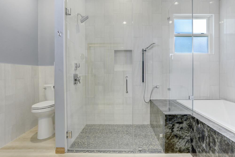 Spring Wagon shower with vertical wall tile, a mosaic floor and a recessed niche